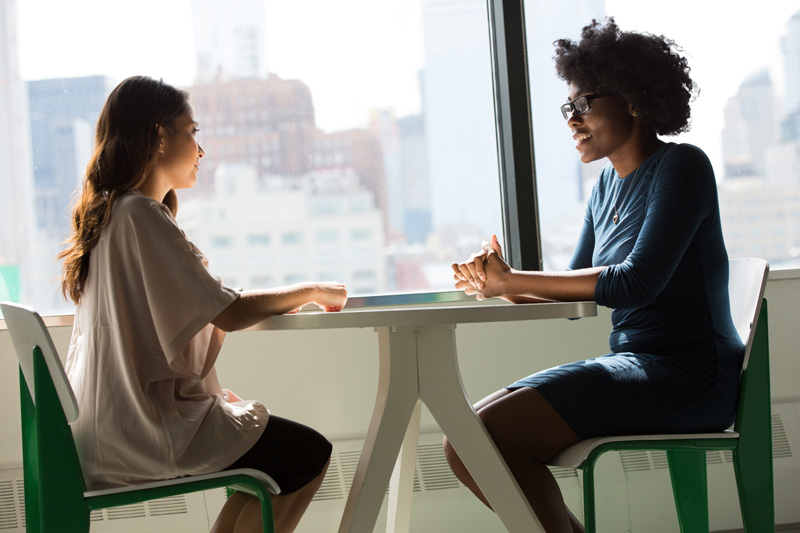 Two women having a meeting in front of a window